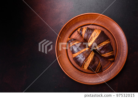 Beautiful tasty fresh crispy croissant on a dark concrete background 97532015