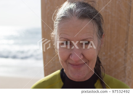 Portrait of happy aged female surfer near sea 97532492