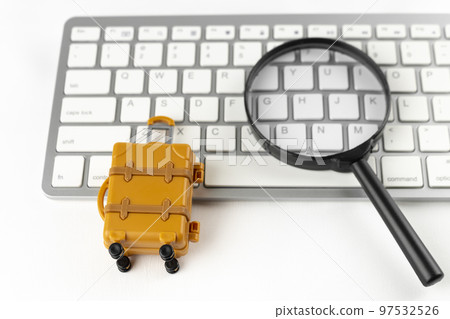 An image of making a reservation for a trip on a computer. A keyboard, a carrying case and a magnifying glass. An image of making a reservation for a trip on a computer. A keyboard, a carrying case and a magnifying glass. 97532526