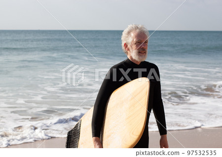 Sporty elderly surfer strengthening health in summer Sporty elderly surfer strengthening health in summer 97532535