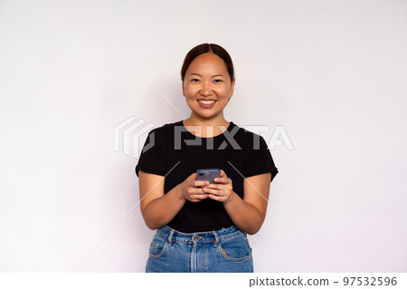 Portrait of happy young woman texting message on mobile phone 97532596