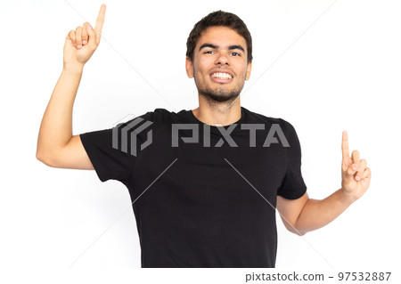 Excited young man pointing fingers up Excited young man pointing fingers up 97532887