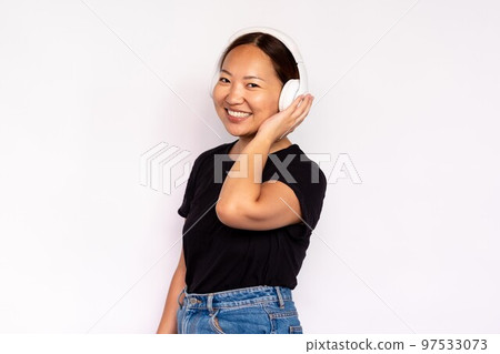 Portrait of happy young woman listening to music in headphones 97533073