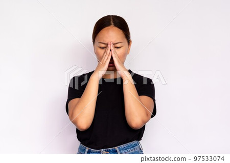 Portrait of depressed young woman rubbing nose 97533074