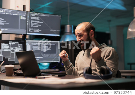 Happy software developer celebrating coding achievement, feeling pleased about app programming success after hours in office. Cheerful smiling coder enjoying victory, coding script. 97533744