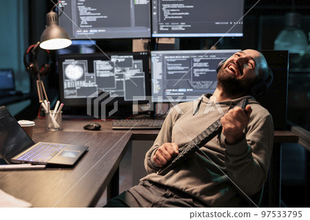 Cheerful programmer singing at air guitar keyboard late at night, working on cloud computing html script. Having fun with artificial intelligence and data on terminal window, fooling around. Cheerful programmer singing at air guitar keyboard late at night, working on cloud computing html script. Having fun with artificial intelligence and data on terminal window, fooling around. 97533795