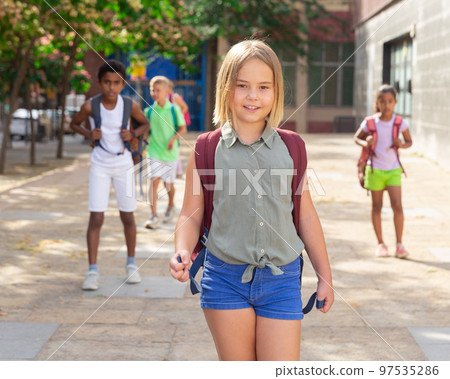 Cheerful preteen girl with backpack going to school on summer day Cheerful preteen girl with backpack going to school on summer day 97535286