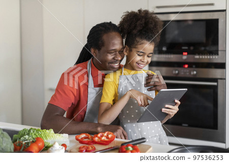 Online Recipe. Happy Black Father And Daughter Using Digital Tablet In Kitchen 97536253