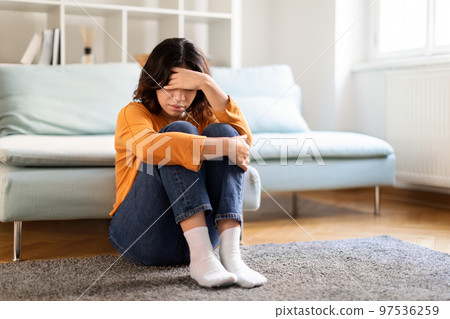 Portrait Of Upset Young Arab Woman Sitting On Floor At Home Portrait Of Upset Young Arab Woman Sitting On Floor At Home 97536259