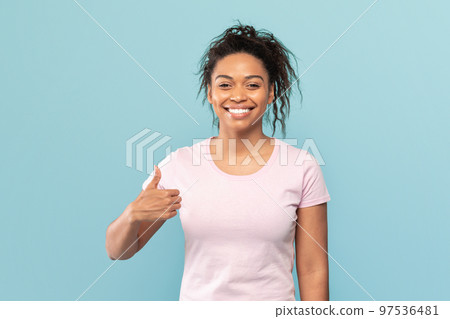 Happy african american woman showing thumb up gesture, recommending or approving something, blue background Happy african american woman showing thumb up gesture, recommending or approving something, blue background 97536481