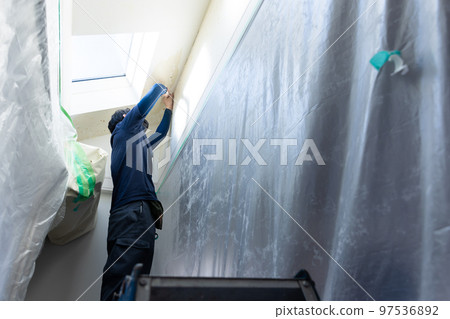 A craftsman who replaces the wallpaper A craftsman who replaces the wallpaper 97536892