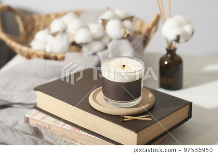 hygge concept. cozy ambient home interior decor with candle, cotton buds and aroma diffuser. burning coconut wax candle hygge concept. cozy ambient home interior decor with candle, cotton buds and aroma diffuser. burning coconut wax candle 97536950