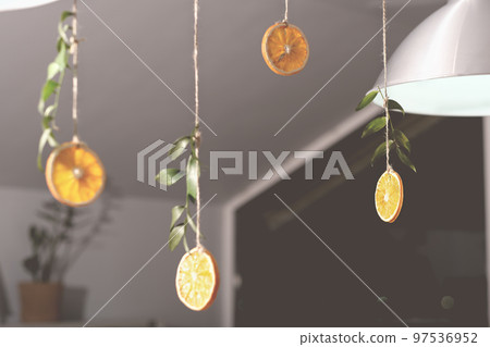 orange slices on a rope hanging under the ceiling in cafe. hipster eco seasonal decor for holiday. orange slices on a rope hanging under the ceiling in cafe. hipster eco seasonal decor for holiday. 97536952