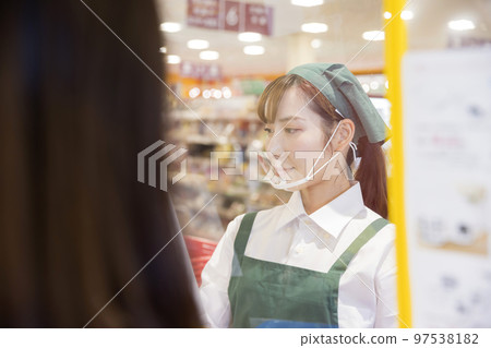 A female employee at a supermarket with infection control 97538182