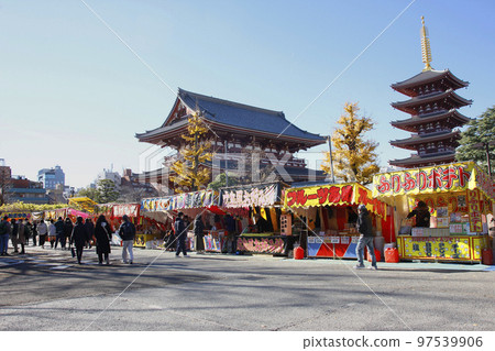 The five-storied pagoda of Senso-ji Temple shines against the blue sky, and people crowd the street stalls below The five-storied pagoda of Senso-ji Temple shines against the blue sky, and people crowd the street stalls below 97539906