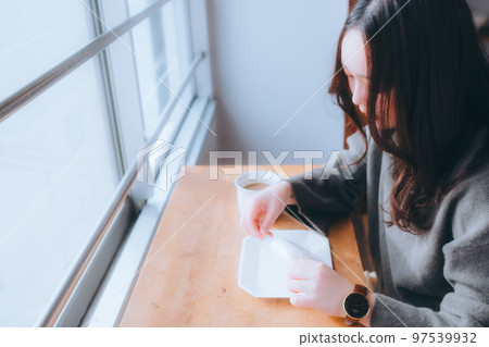 年輕女子在家吃甜甜圈的照片 年輕女子在家吃甜甜圈的照片 97539932