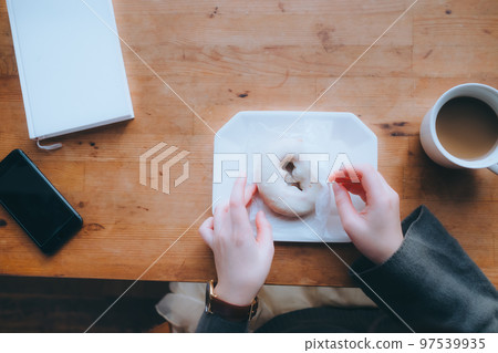 Photo of young woman eating donuts at home Photo of young woman eating donuts at home 97539935