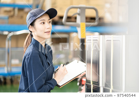 Young female worker working in distribution warehouse Young female worker working in distribution warehouse 97540544