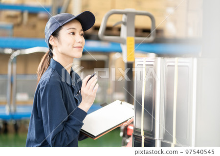 Young female worker working in distribution warehouse Young female worker working in distribution warehouse 97540545