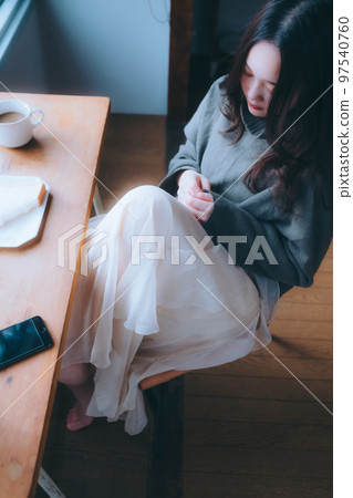 一位年輕女子在她的房間裡吃早餐的照片 一位年輕女子在她的房間裡吃早餐的照片 97540760