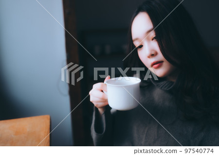 一位年輕女子在她的房間裡吃早餐的照片 一位年輕女子在她的房間裡吃早餐的照片 97540774