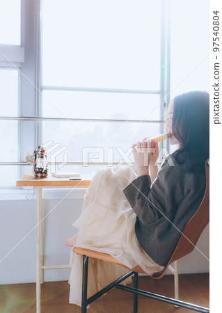 一位年輕女子在她的房間裡吃早餐的照片 一位年輕女子在她的房間裡吃早餐的照片 97540804