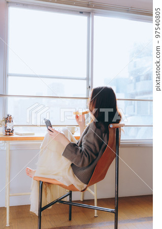 一位年輕女子在她的房間裡吃早餐的照片 一位年輕女子在她的房間裡吃早餐的照片 97540805