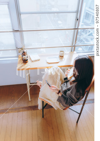 一位年輕女子在她的房間裡吃早餐的照片 一位年輕女子在她的房間裡吃早餐的照片 97540807