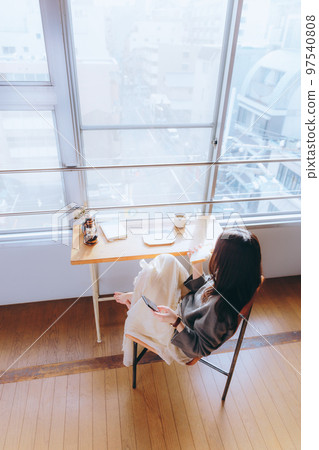 Photo of a young woman eating breakfast in her room 97540808