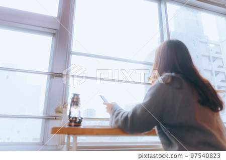 一位年輕女子在她的房間裡吃早餐的照片 97540823