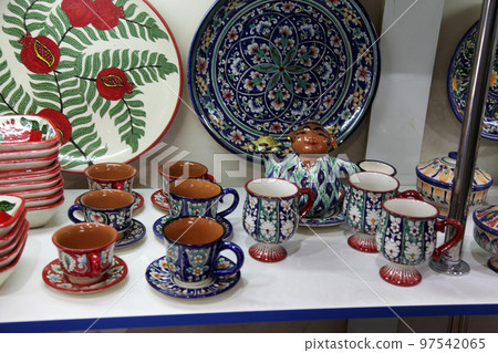 Ceramic souvenir plates, vases, tea sets on the shelves of a store in Samarkand in Uzbekistan. 29.04.2019 Ceramic souvenir plates, vases, tea sets on the shelves of a store in Samarkand in Uzbekistan. 29.04.2019 97542065