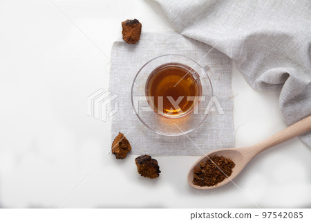 Healthy drink coffee from chaga mushroom in a glass cup on a white background. Top view. Copt spaes. 97542085