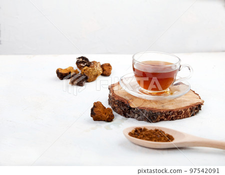 Healthy drink coffee from chaga mushroom in a glass cup on a white background. Top view. Copt spaes. 97542091