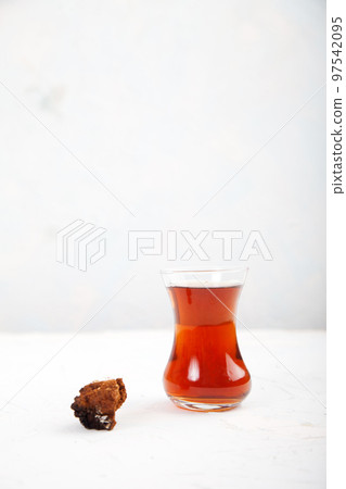 Chaga tea in a Turkish glass on a light background. Healthy food concept. Copy spaes. 97542095