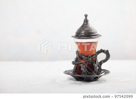 Chaga tea in a Turkish glass on a light background. Healthy food concept. Copy spaes. 97542099