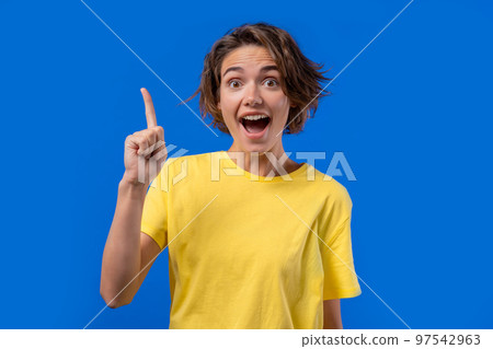 Happy woman having idea eureka moment, pointing finger up on blue background. Smart student girl 97542963
