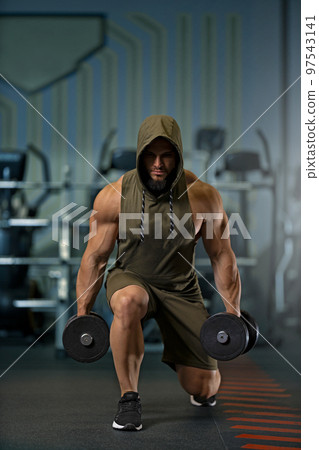 Strong man doing lunges with dumbbells in the gym Strong man doing lunges with dumbbells in the gym 97543141