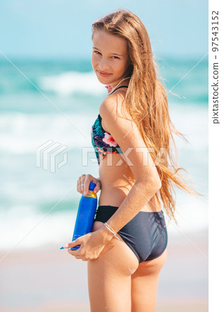 Happy young girl with sunblock on tropical beach vacation Happy young girl with sunblock on tropical beach vacation 97543152