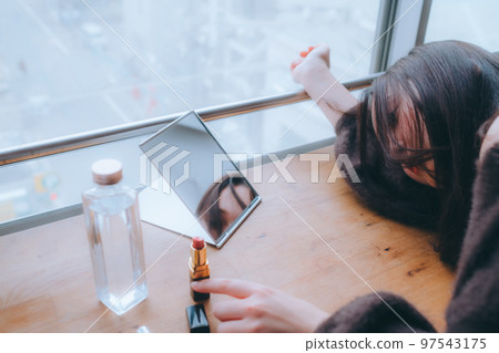 Photo of young woman doing morning makeup Photo of young woman doing morning makeup 97543175