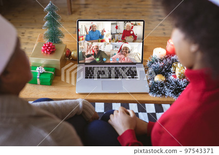 African american couple having christmas video call with diverse people African american couple having christmas video call with diverse people 97543371