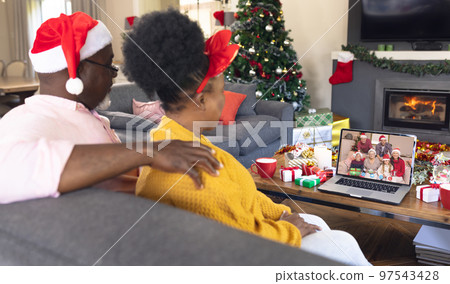 Senior african american couple having christmas video call with caucasian family Senior african american couple having christmas video call with caucasian family 97543428