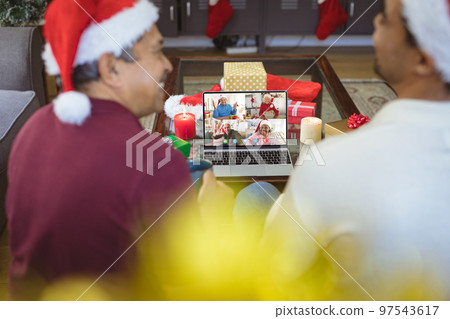 Senior biracial man and his adult son having christmas video call with diverse people Senior biracial man and his adult son having christmas video call with diverse people 97543617