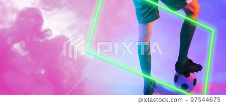 Low section of caucasian male player with leg on ball over illuminated rectangle shape against smoke 97544675