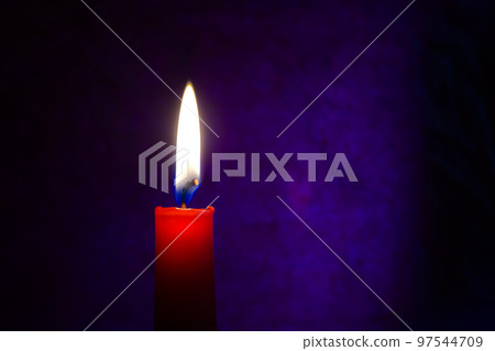 Single red candle burning alone in the dark blue 97544709