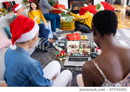 Diverse friends with christmas decorations having video call with happy caucasian friends Diverse friends with christmas decorations having video call with happy caucasian friends 97545002