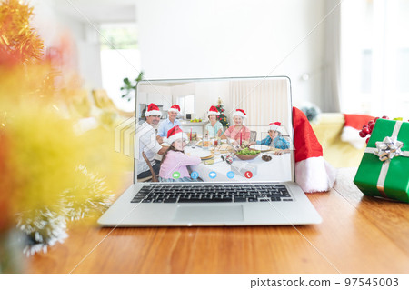 Happy caucasian family with santa hats and christmas decorations having christmas laptop video call Happy caucasian family with santa hats and christmas decorations having christmas laptop video call 97545003