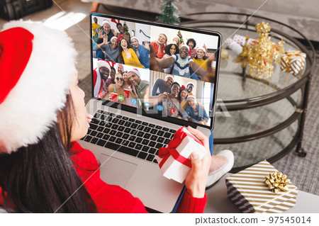 Caucasian woman with santa hat having video call with happy diverse friends Caucasian woman with santa hat having video call with happy diverse friends 97545014