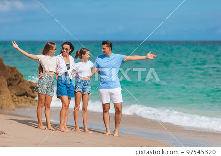 Family of four have fun together on beach vacation in Florida 97545320