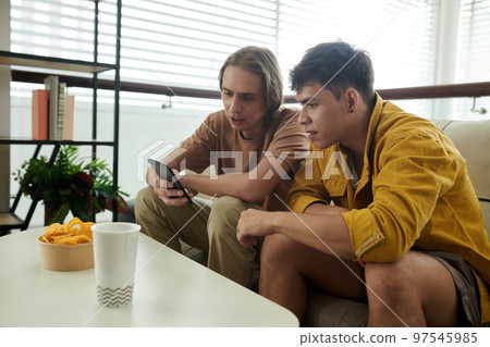 Young men using dating app on smartphone when looking for partner Young men using dating app on smartphone when looking for partner 97545985