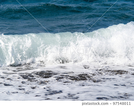White waves on the beach. 97548011